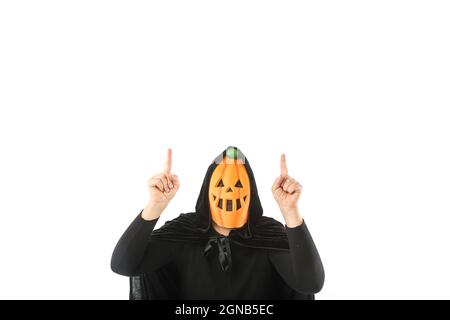 Person dressed in pumpkin Jack-o.-lantern mask and hooded velvet cape, pointing fingers up with copy space, on white background. Carnival, Halloween a Stock Photo