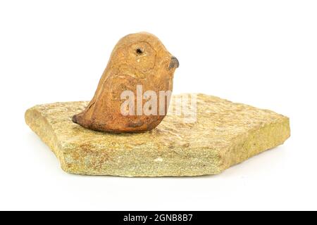 Ceramic bird on flat rock isolated on white background Stock Photo