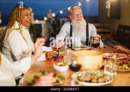 Senior people having fun at patio dinner party - Focus on hipster male face Stock Photo