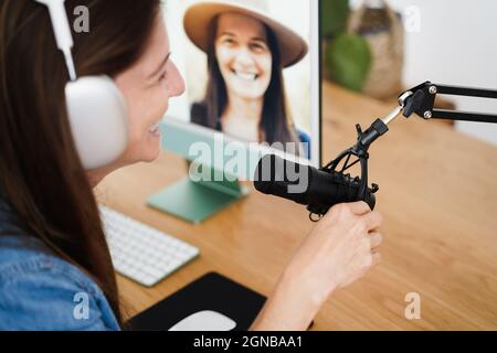 Influencer woman doing podcast using computer at home - Technology trend concept - Focus on microphone Stock Photo