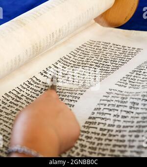 Young Jewish man reading torah wearing kippah, praying shawl & tefillin ...