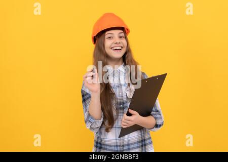building and construction. happy child worker wear hardhat hold clipboard. childhood development Stock Photo