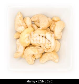 Closeup of cashew nuts in a white bowl on a white background Stock Photo