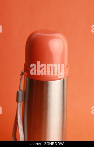 Orange and silver thermos on an orange background Stock Photo