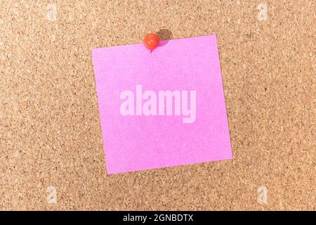 Blank pink note and push pin on cork board. Template to ad text or drawings Stock Photo