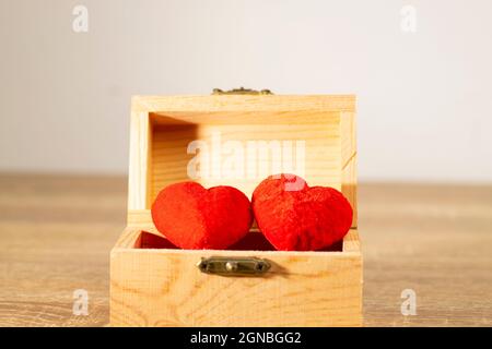 Two red hearts in the brown treasure box. It’s full with love and full fill sweet moment for couple is love each other. Next step is wedding and live Stock Photo