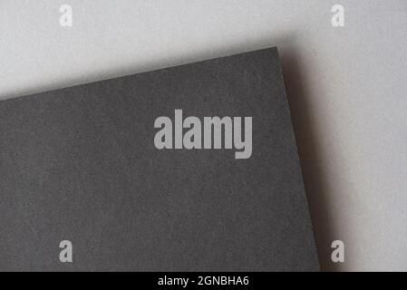 Black sheet on the top of gray. Two blank dark cadboard sheets as mock up with space for text, top view Stock Photo