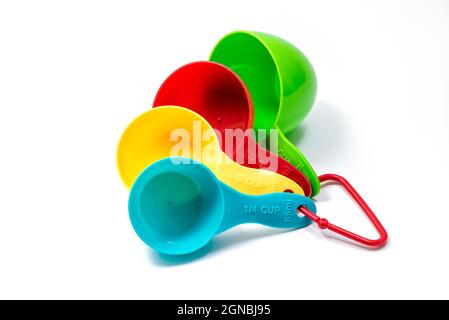 Four pieces of colorful ingredient measuring scoops or spoons of different cup sizes connected together. Isolated on white background with Clipping pa Stock Photo