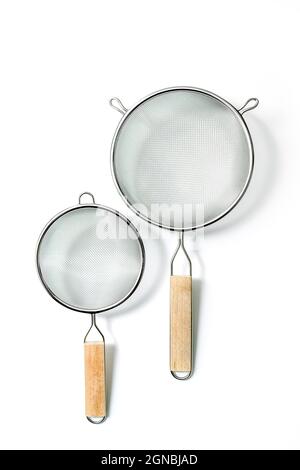 Two Fine Mesh Strainers - large and small. Silver colored metalic colanders with wooden handle isolated on a white background Stock Photo