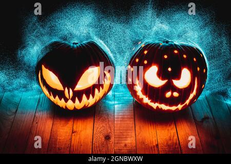 halloween pumpkins on wooden planks with abstract led lights in the background. Stock Photo