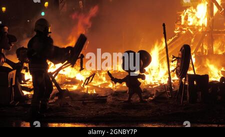 Firefighter burning ninots in the fire of La Cream on Fallas celebration, Spain Stock Photo