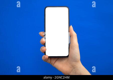 Mobile phone mockup screen on a blue background, copy space Stock Photo