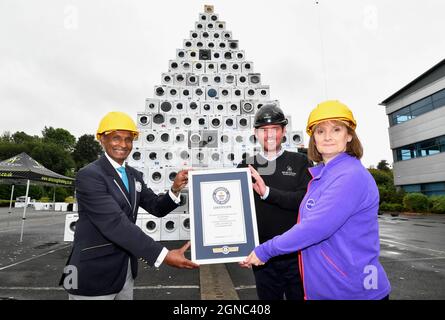 EDITORIAL USE ONLY Pravin Patel (left), Guinness World Records official adjudicator presents a certificate to Richard Crayston, Managing Director at Ainscough Training Services and Lindsey Hazlehurst from Currys PC World, in Bolton, as the retailer receives the Guinness World Records title for the 'largest pyramid of washing machines', to mark National recycling Week. Picture date: Friday September 24, 2021. Stock Photo