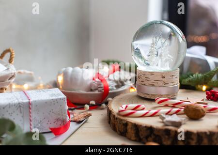 Christmas decorations, a snow globe and presents and star shaped biscuits. Stock Photo