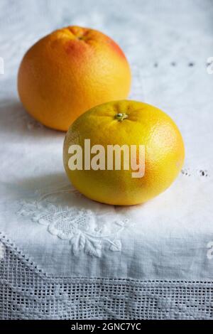 Ripe grapefruits on a white screwed tablecloth. Stock Photo