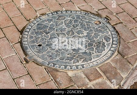 Ryazan, Russia - July 7, 2021: Metal manhole cover on urban pavement road Stock Photo
