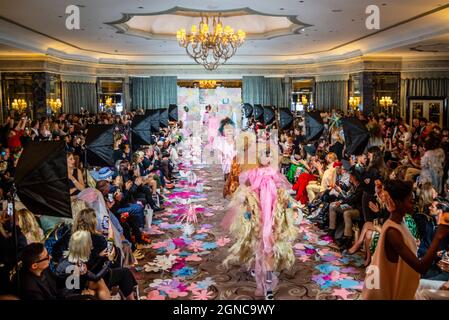 Models on the catwalk in the ballroom of Dorchester Hotel for the finale of Vin + Omi Future Flowers fashion show for London Fashion Week. Audience Stock Photo