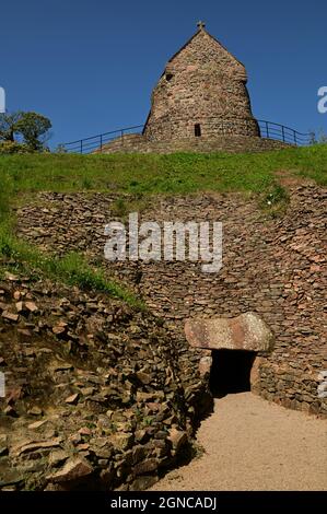 An exterior view of the medieval stone church building on top of a Neolithic burial mound at La Hogue Bie on the Island of Jersey. Stock Photo