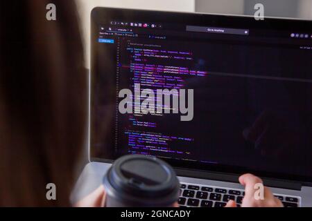 A programmer coding on a laptop in the workplace Stock Photo