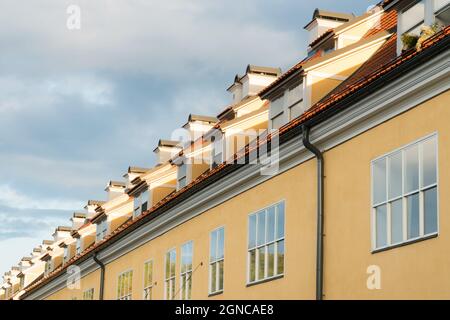 Attic-type windows of historical buildings complex with red-tiled roof known as Jacob’s Barracks located in Old Town Riga, Latvia. A perspective from Stock Photo