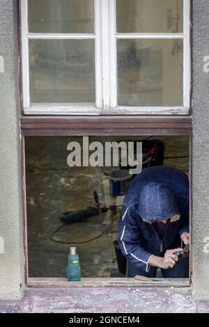 A worker works on the reconstruction of a window in the house Stock Photo
