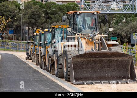 Tractors, bulldozers standing in a row. standing heavy construction wheeled bulldozer close up. Stock Photo