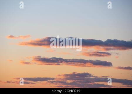 Fiery orange sunset sky. Beautiful perfect sky for your photos. Cloudscape of cumulus sunset clouds with sunlight, evening sky. Heavenly background to Stock Photo