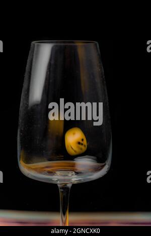 Transparent dirty glass with color dice on color wooden table Stock Photo