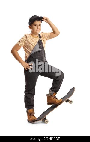 Full length portrait of a boy posing standing on a skateboard and holding his cap isolated on white background Stock Photo