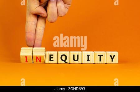 Inequity or equity symbol. Businessman turns wooden cubes and changes the word inequity to equity. Business and inequity or equity concept. Beautiful Stock Photo