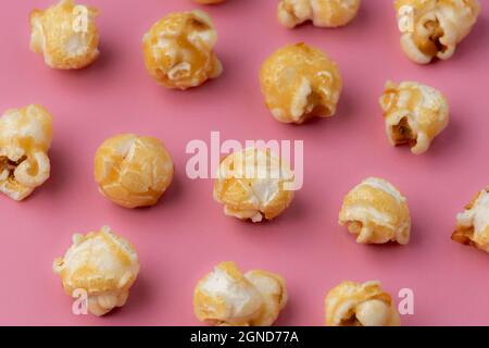 Toffee popcorn on a bright pink background in an abstract layout Stock Photo