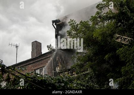 Fire in a residential five-story building. Firefighters extinguish the fire with water from a gunboat. Stock Photo