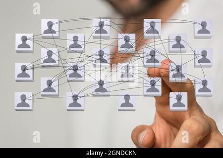 Illustration of person icons connected by lines with a man's hand tapping on it from the background Stock Photo