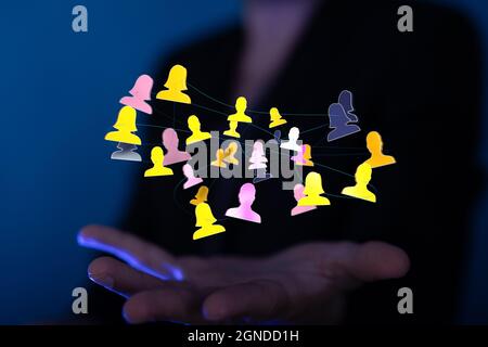 Illustration of person icons connected with lines hovering over a man's palm Stock Photo
