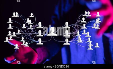 Illustration of person icons connected with lines hovering between man's palms Stock Photo