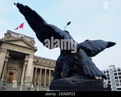 Sculpture of a bronze harpy in front of the facade of the courthouse in Lima Stock Photo