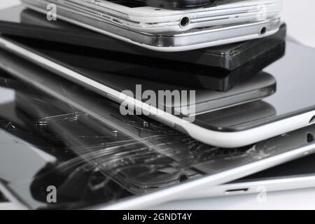 Broken Mobile Smart Phone and pad with crashed Screen Glass Lcd.  gadgets lying one on top of another. Devices are prepared for utilization. Stock Photo