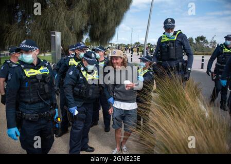 Melbourne, Australia. 25th Sep, 2021. 25th September 2021, Melbourne, Australia. Police arrest a smiling protester at an attempted 'Millions March' rally in St Kilda. Credit: Jay Kogler/Alamy Live News Credit: Jay Kogler/Alamy Live News