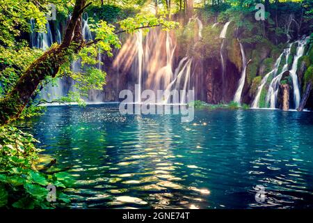 Last sunlight lights up the pure water waterfall on Plitvice National Park. Colorful spring scene of green forest with blue lake. Great countryside vi