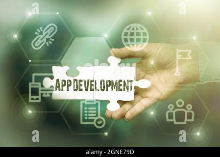 Handwriting text App Development. Word for Development services for awesome mobile and web experiences Hand Holding Jigsaw Puzzle Piece Unlocking New Stock Photo