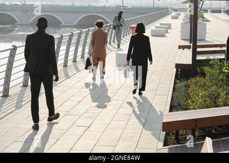 Horizontal long shot of modern business people and office workers going to their workplaces on sunny summer morning Stock Photo