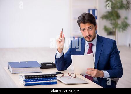 Young businessman employee reading paper at workplace Stock Photo