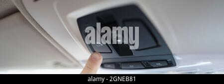 Man with his finger pressing emergency button in car closeup Stock Photo