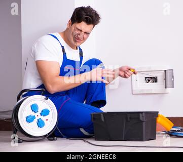 The funny man doing electrical repairs at home Stock Photo
