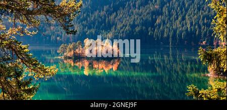 Amazing autumn panorama of Eibsee lake. Sunny morning view of small island on bottom of the Zugspitze peak, Bavaria, Germany, Europe. Beauty of nature Stock Photo