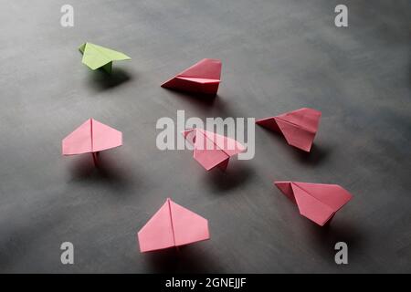 Leadership, cooperation, teamwork and followers concept. Red paper planes follow green paper plane Stock Photo