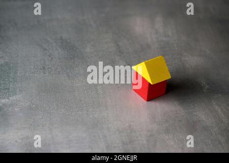 House made from wooden cubes on concrete floor. Copy space for text. Stock Photo