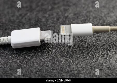 VLADIVOSTOK, RUSSIA - SEPTEMBER 24, 2021: Apple Lightning Connector and USB Type-C cables. Selective focus. Stock Photo