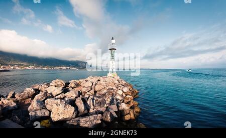 Small lighthouse in the port of Kamena Vourla town. Foggy spring morning on the Aegean Sea. Picturesque outdoor scene in Greece. Beauty of countryside Stock Photo
