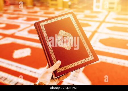 hand holding quran. High quality and resolution beautiful photo concept Stock Photo